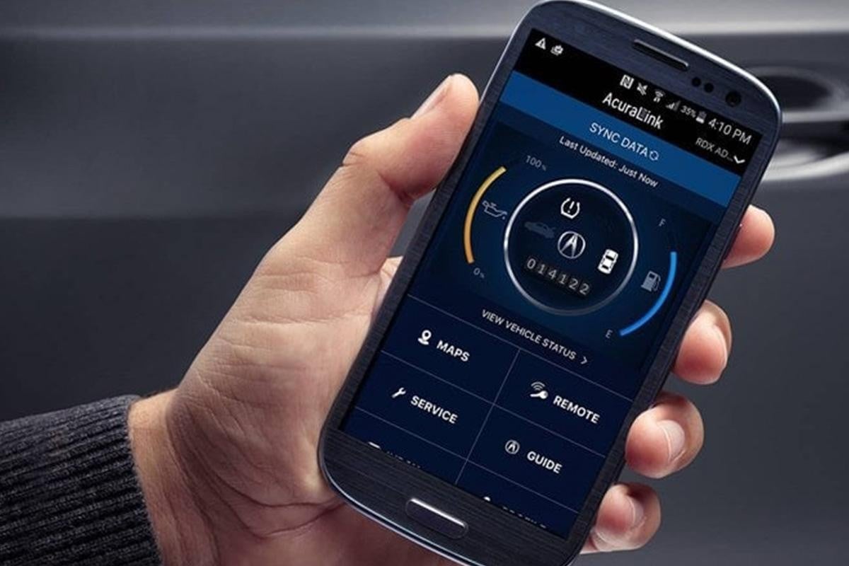 Hand holding smartphone displaying AcuraLink vehicle status app