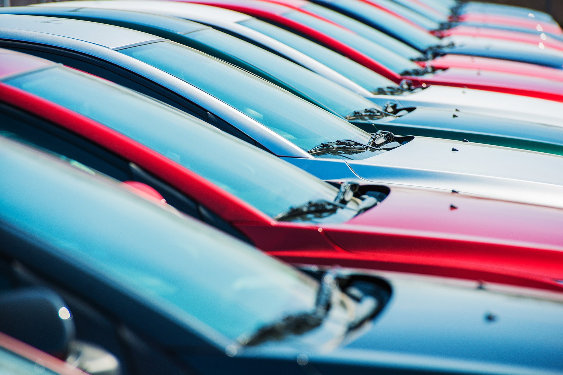 Row of colorful cars parked in a dealership lot