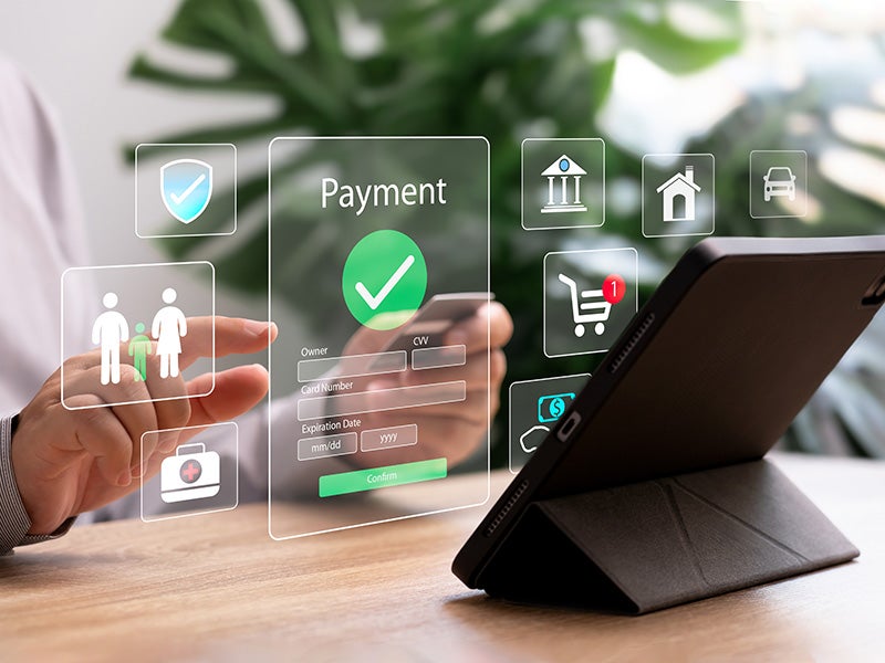 Person making an online payment using a tablet with digital icons