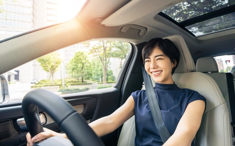 Woman in car receiving car key with a smile