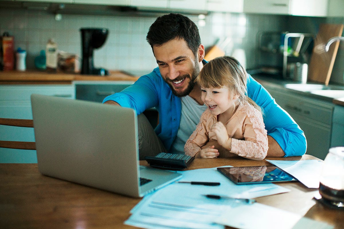 Man showing young girl something on a laptop